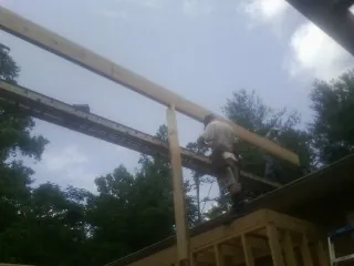 Carpenter setting a ridge beam over a new addition frame — Ice Dam Removal by Roofing Brothers in Lawnside