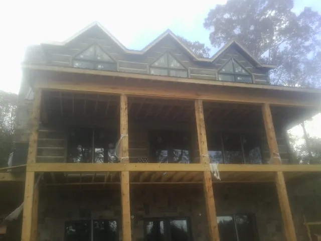 Dormers and porch framing on a large log home under construction — Roof Coating work by our crew in Lawnside