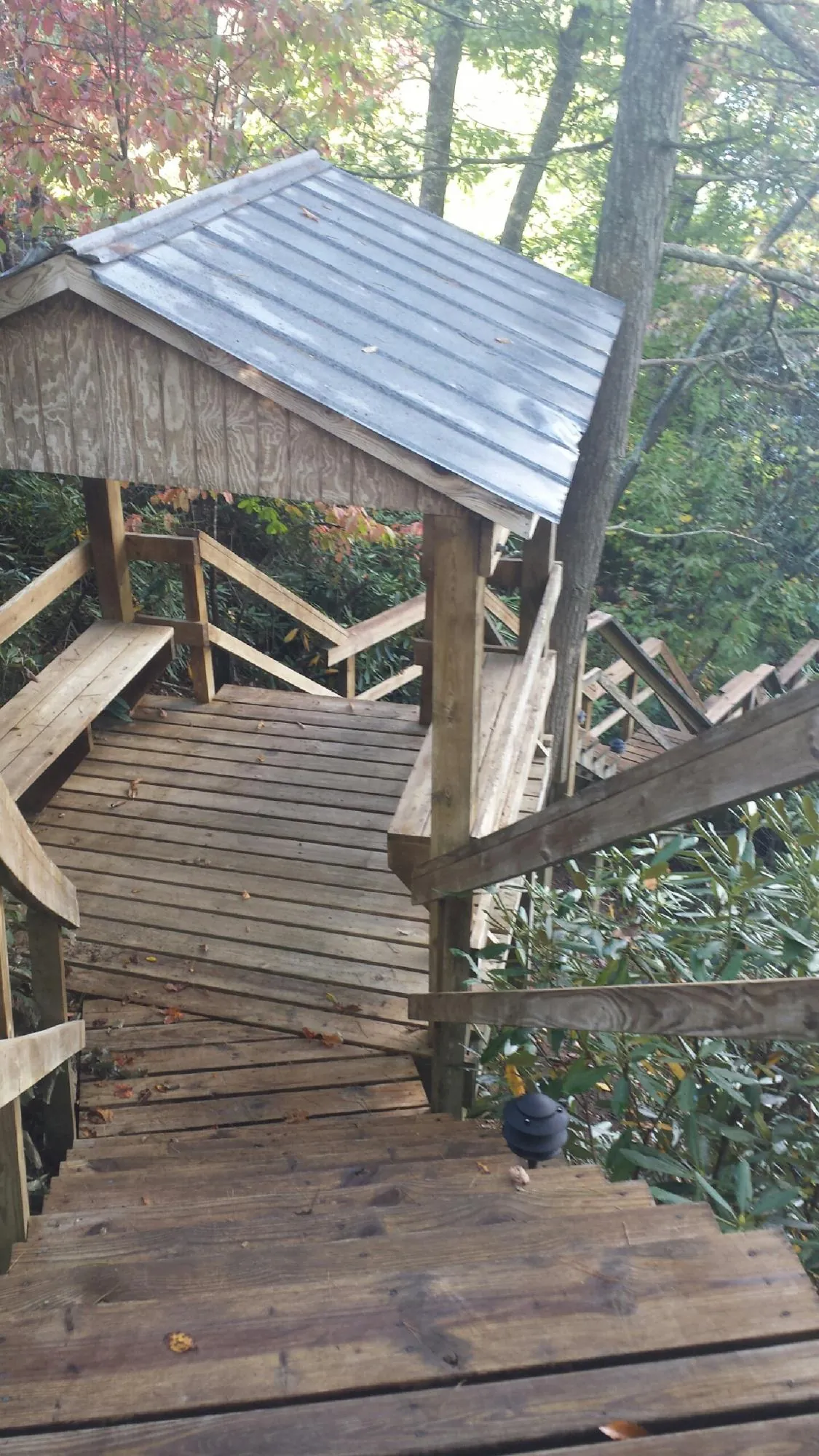 Metal roofed shelter over wooden steps on a wooded walkway — Skylight Repair & Installation work by our crew in Lawnside